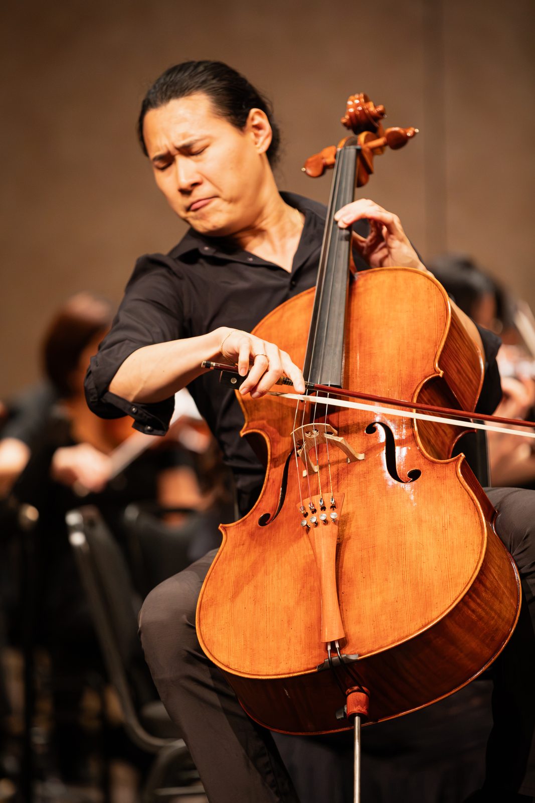 Jonah Kim playing the cello in concert, eyes closed